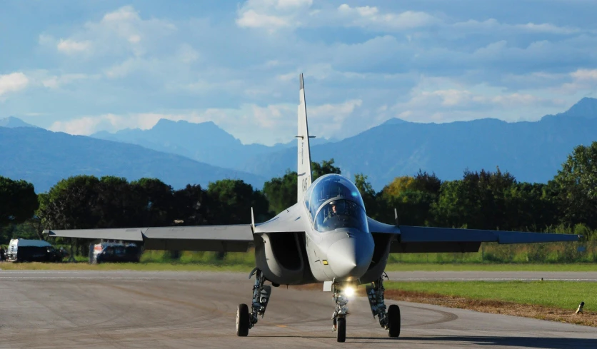 a fighter jet sitting on top of an airport runway