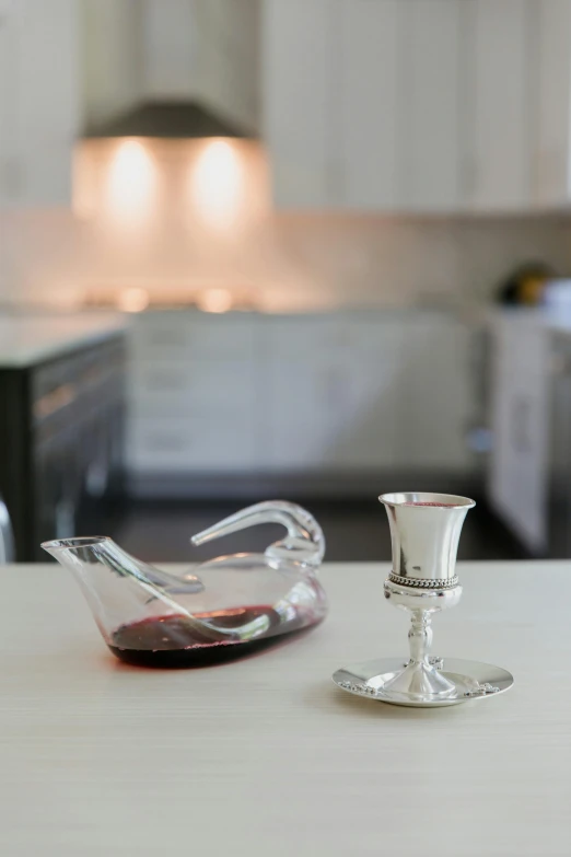 a silver candela with red wine next to it