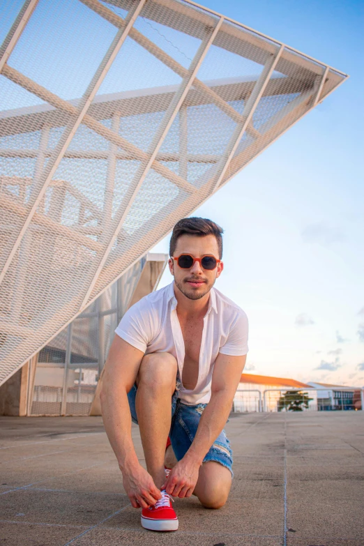 a man with sunglasses is bent over wearing shorts