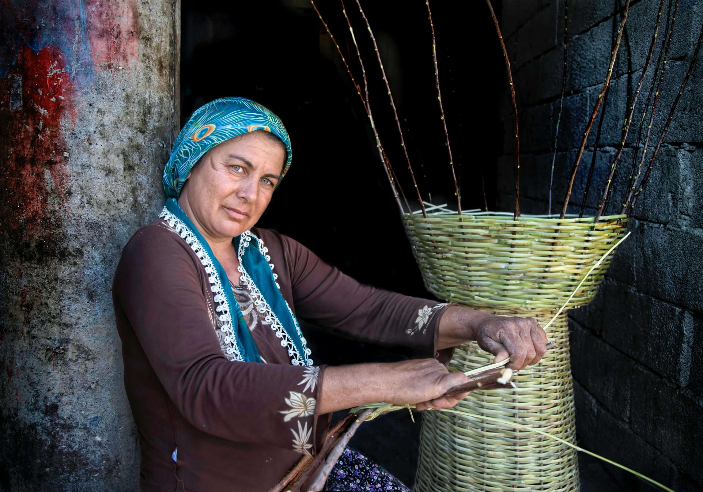 a woman with a head scarf holding a large basket