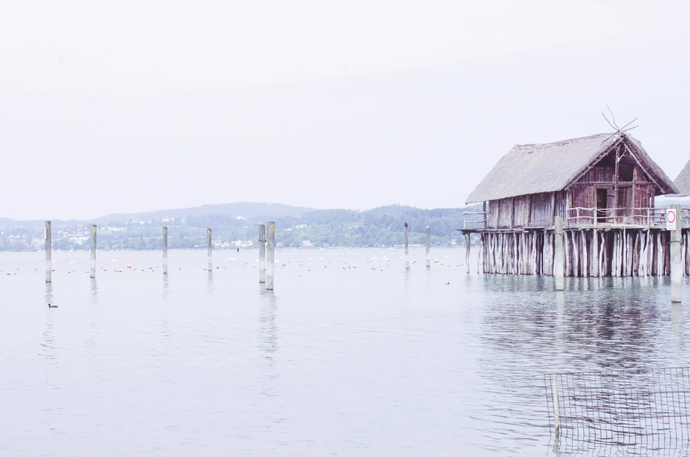 houses are on stilts in the water by a pier