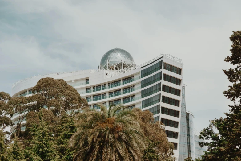 a round building next to a group of trees with a dome on top