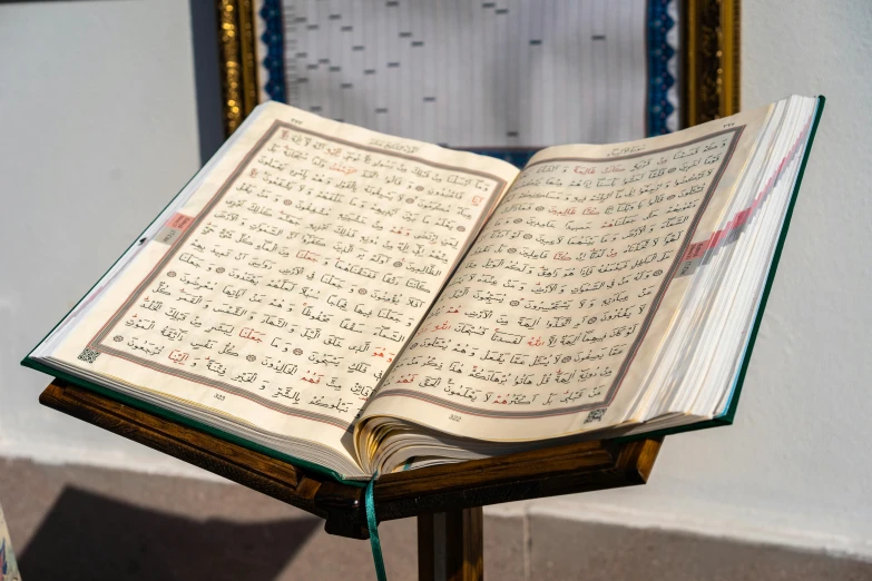 the opened book is lying on a stand