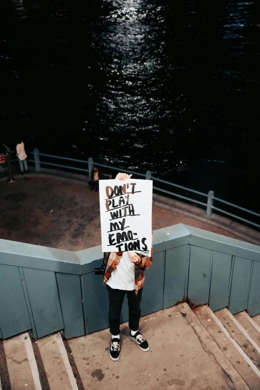 woman holding up a sign that says don't enter with feelings