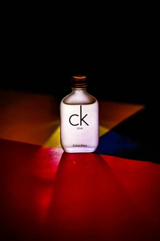 a bottle with the letter c on it is sitting next to a colorful table