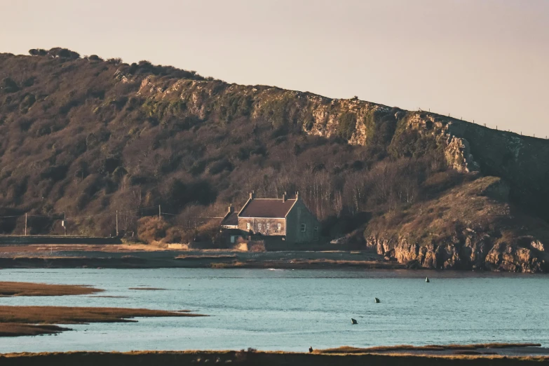 houses perched on top of hill next to a body of water