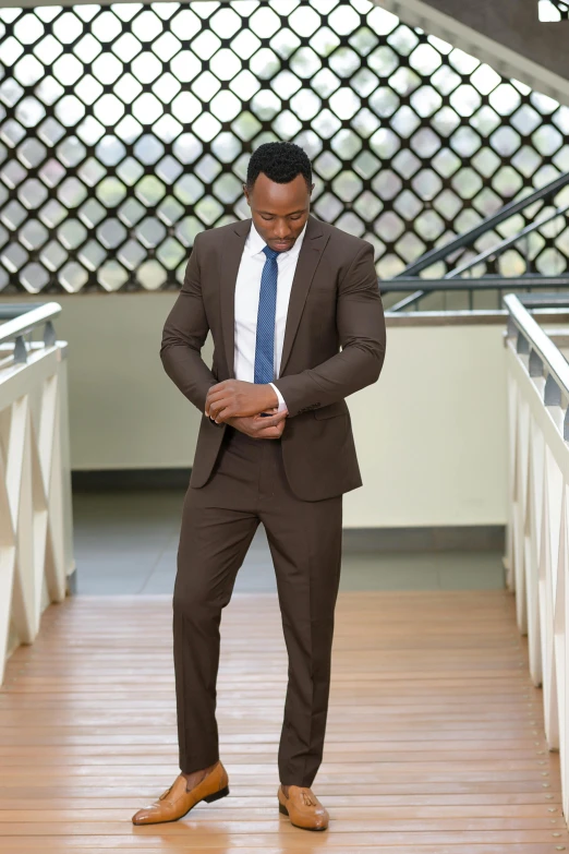 a young man is standing in a hall wearing a suit and tie