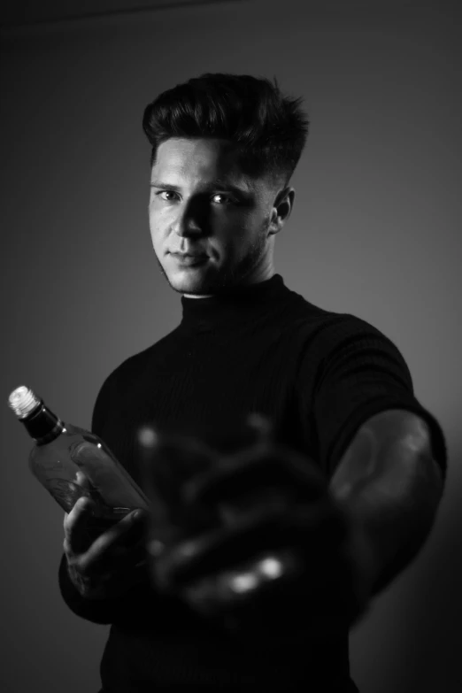 a man holding a bottle while looking at the camera