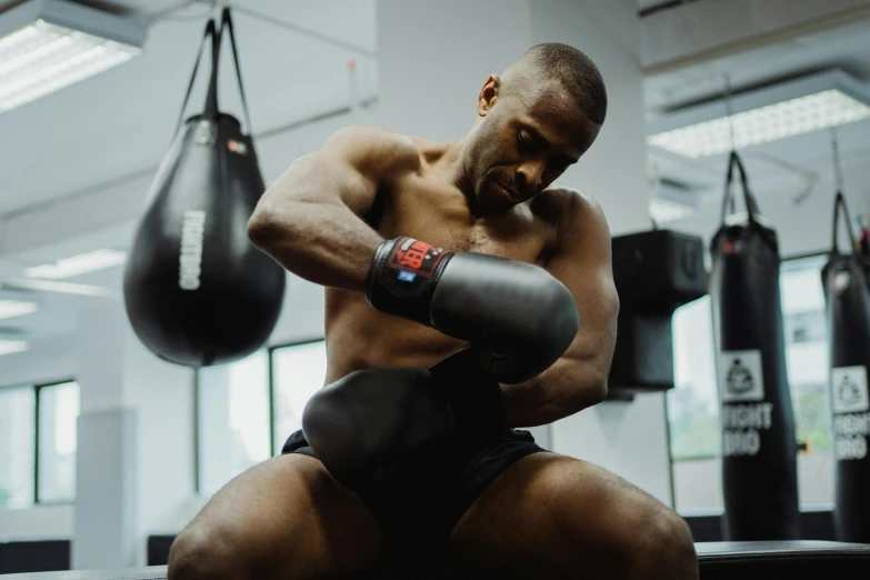 a muscular man in the gym using his punching gloves