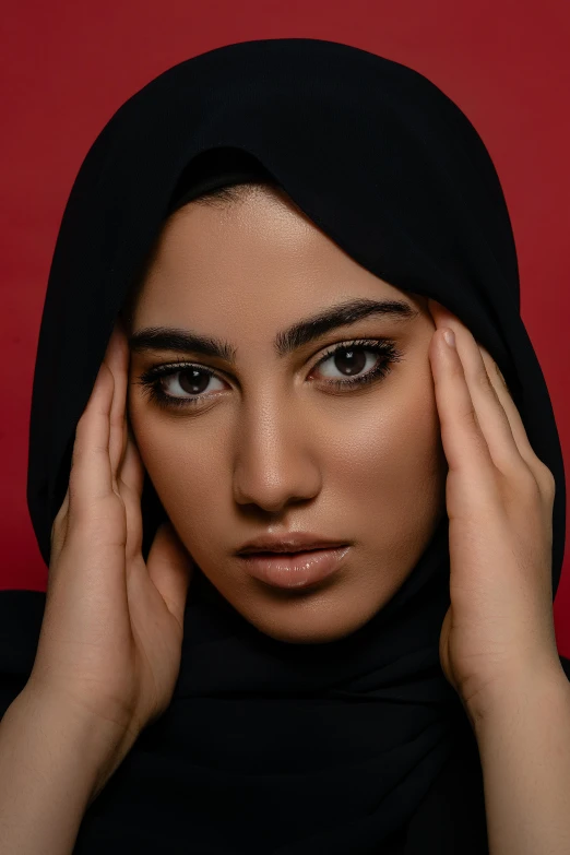 a woman wearing a black head scarf posing for a pograph