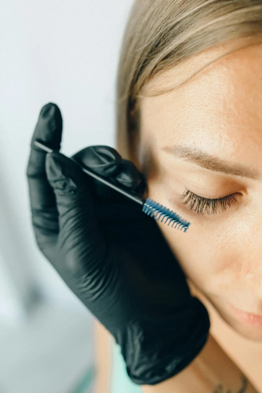 a woman is getting her lashes done by an experienced professional