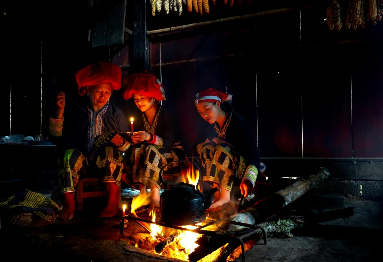 a group of women standing around a fire pit in a kitchen