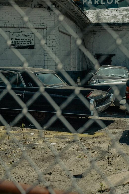 old cars parked in front of a building with barbed wire