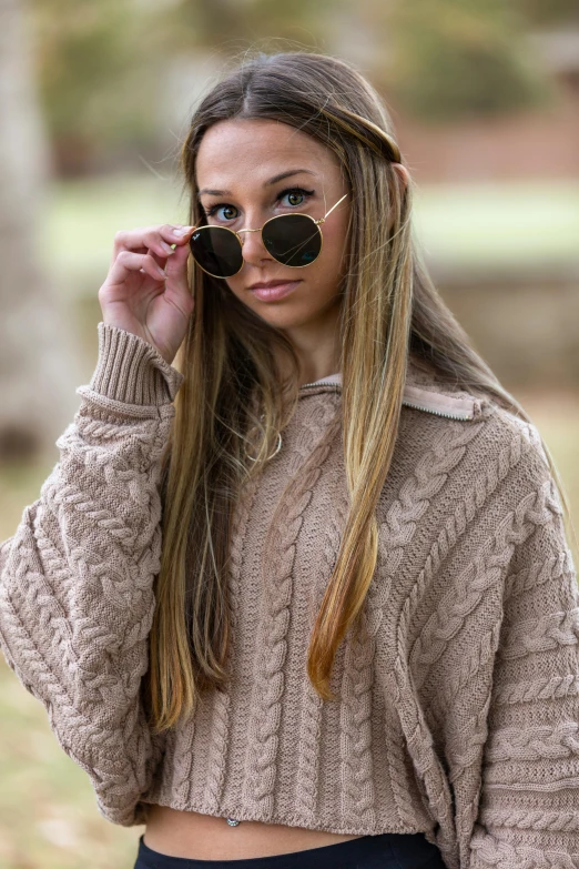 young beautiful woman holding her sunglasses to her eye