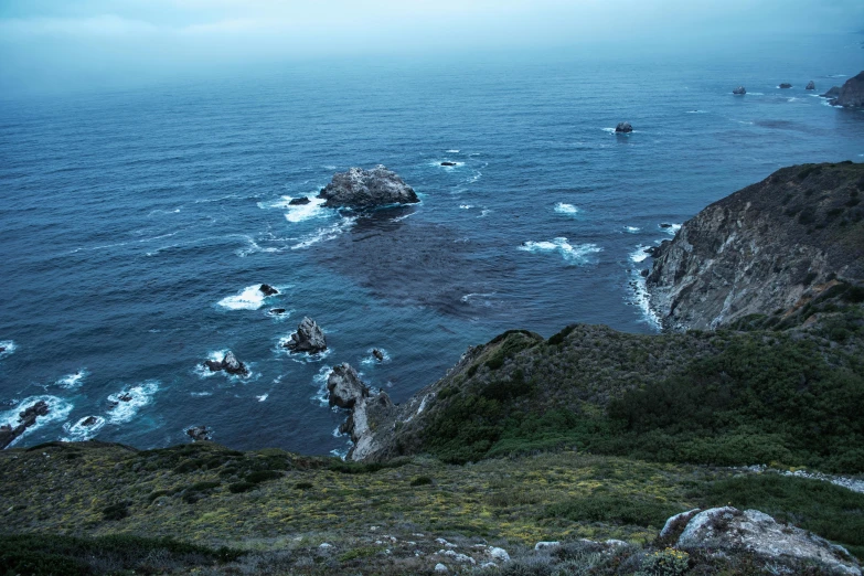 large waves crash on the rocks at the edge of a cliff