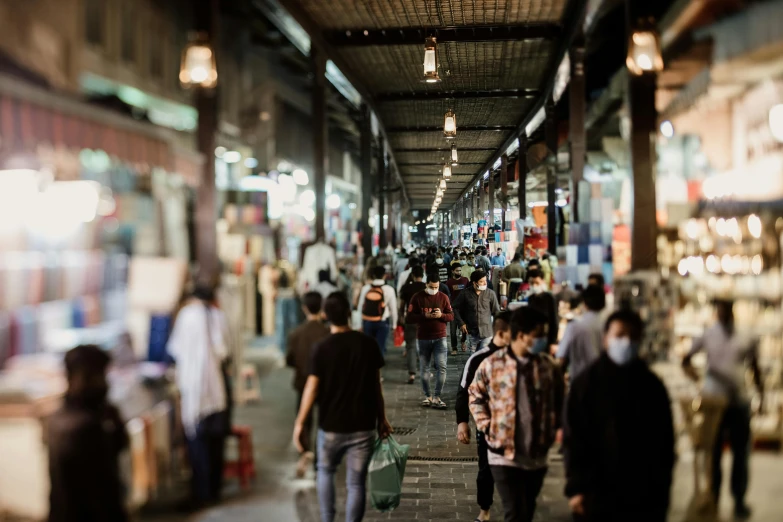 several people walk down a walkway between two buildings