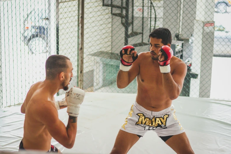 a man with  is boxing next to another man