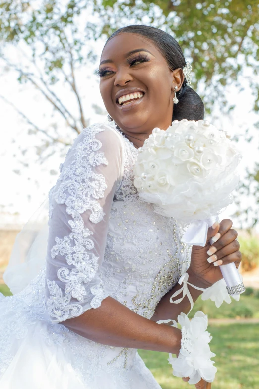 the bride smiles as she poses with her bouquet