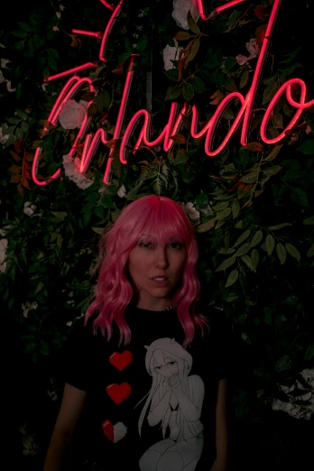 a pink haired woman standing under a neon sign