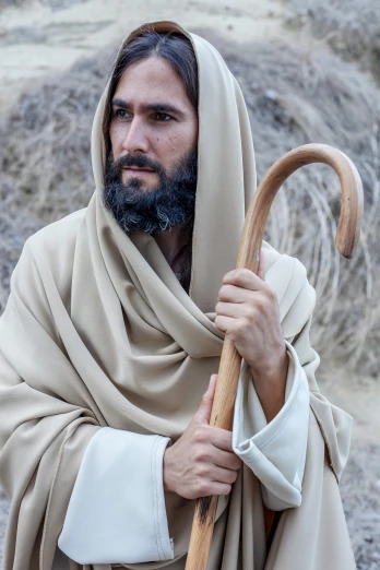a man with an cross holding a staff