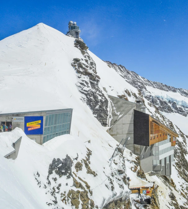 some snow and a building on top of a snowy mountain