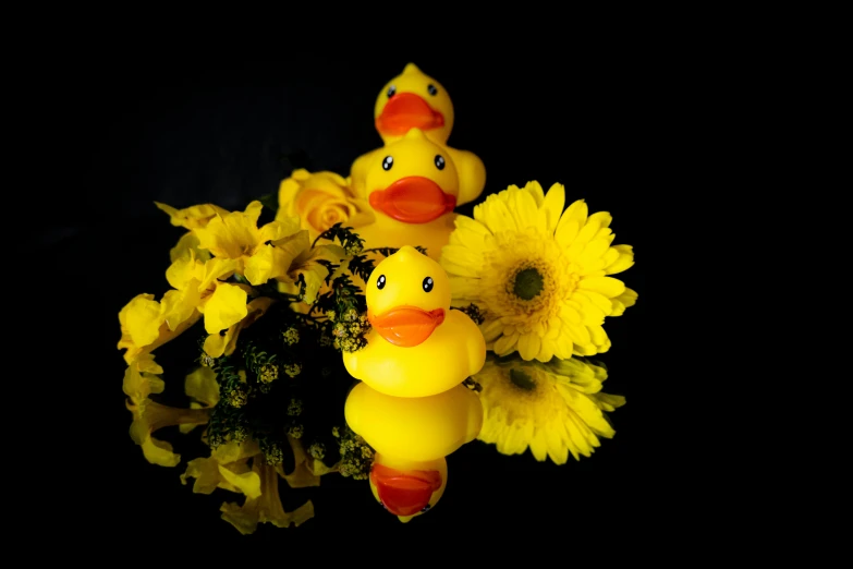 a close up of a vase of flowers with a rubber duck and chicks