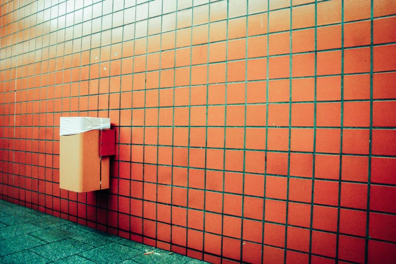 an orange wall with a cardboard box on it