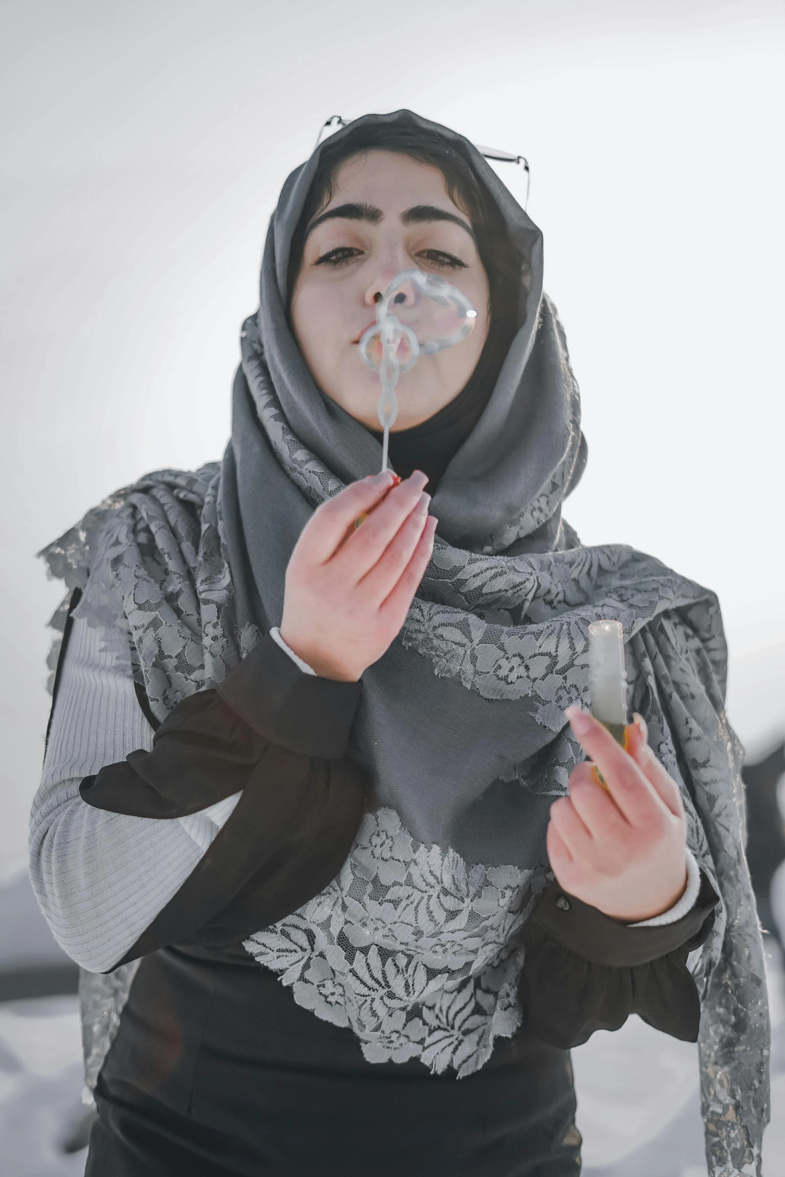 an afghan woman smoking electronic cigarette with a cigarette holder