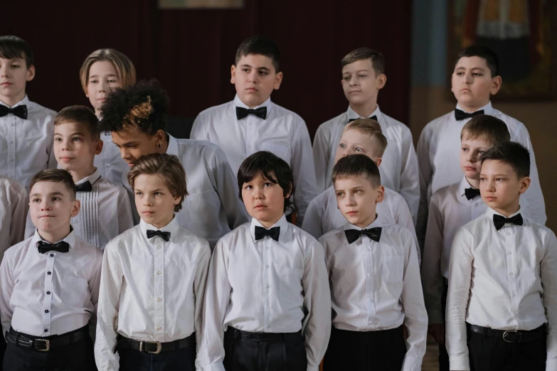 several s and girls wearing formal white shirts and bow ties