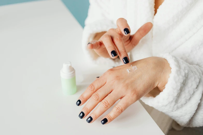 the woman has black manicures and is leaning on a table