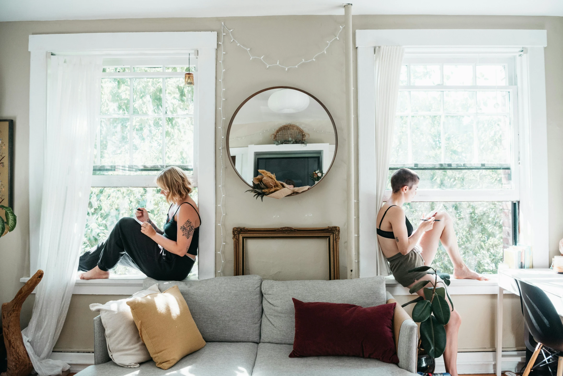 two girls sit on the window sill in their living room