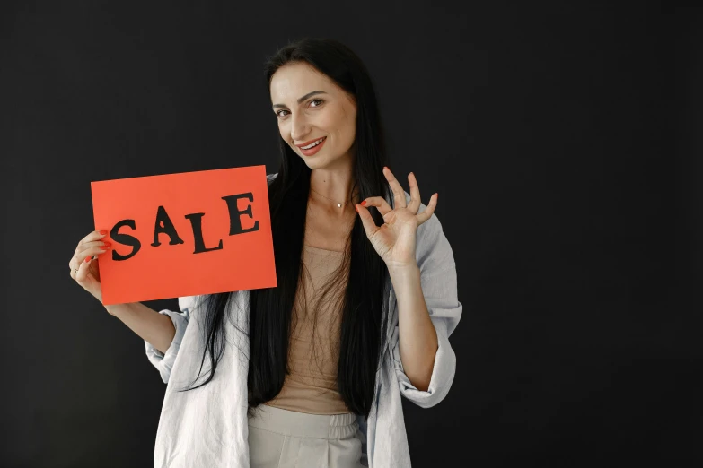 a woman holding a sign that says sale