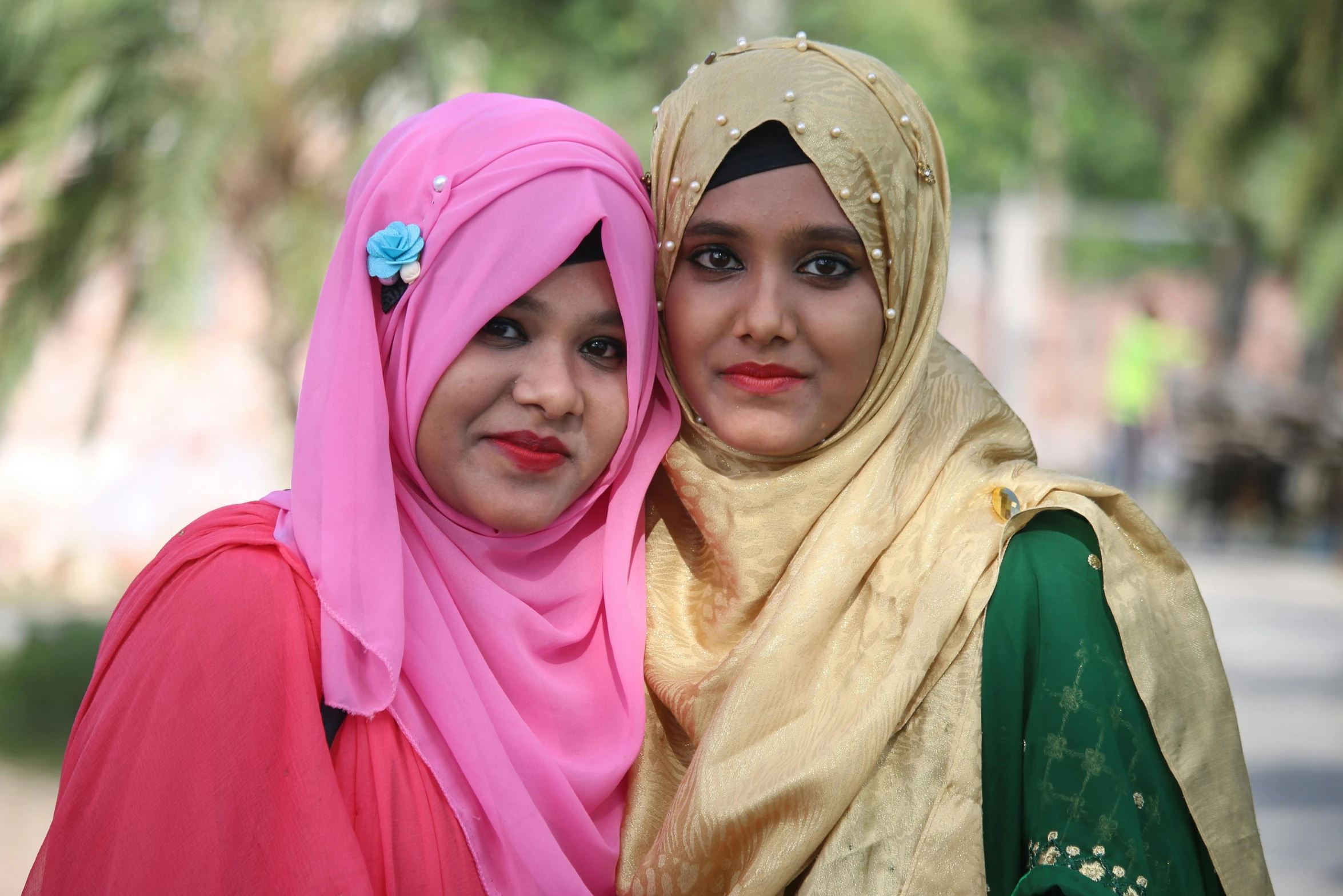 two girls pose for the camera with headscarves on