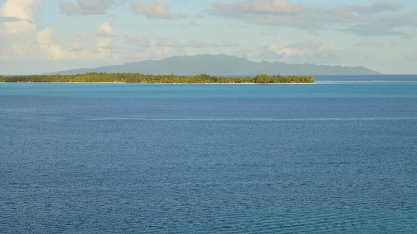 a boat on the ocean with an island in the background