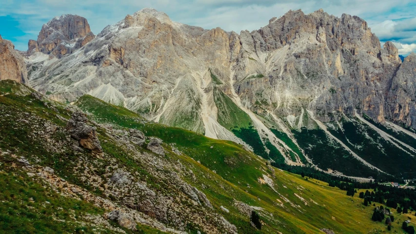 many mountain tops rise above green grassy mountains