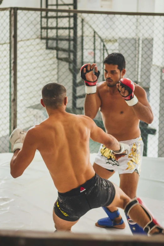 two young men are boxing on the court