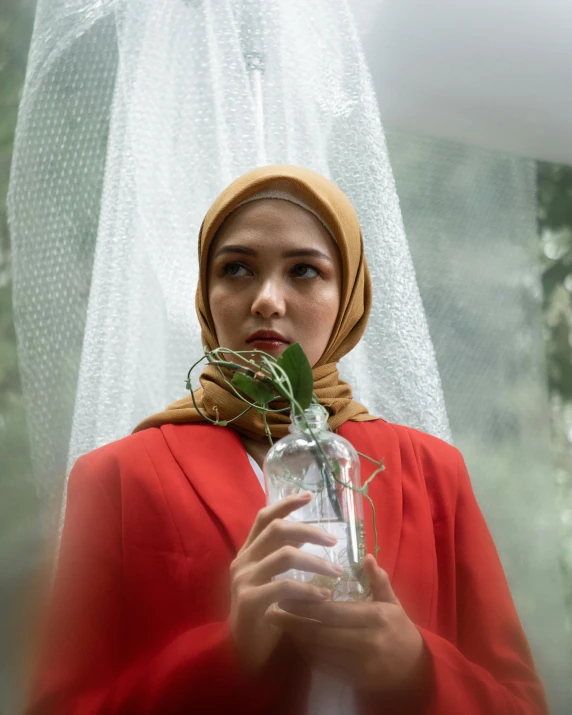 a woman wearing a red shawl and holding a mason jar