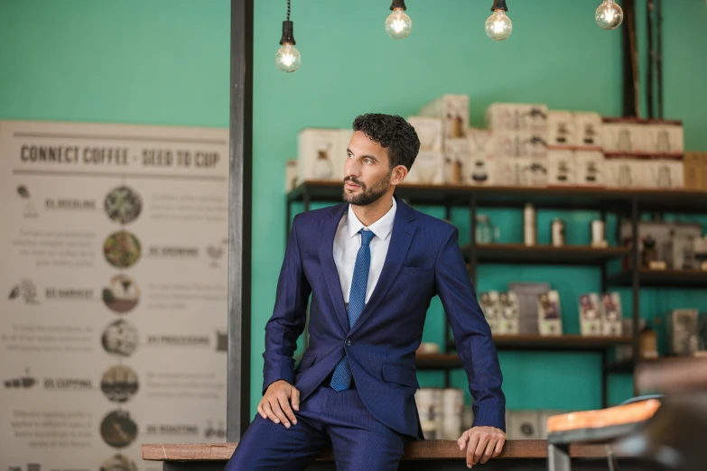 a man in a blue suit is sitting at the counter