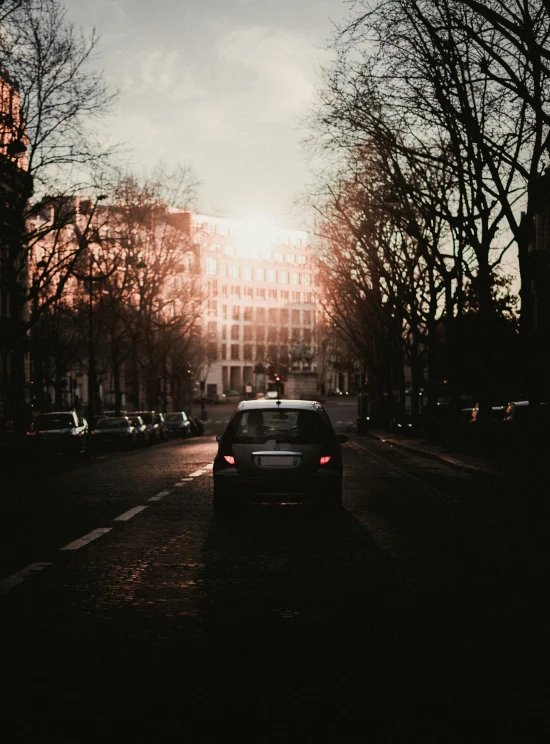 a car parked on the side of a road near a tall building