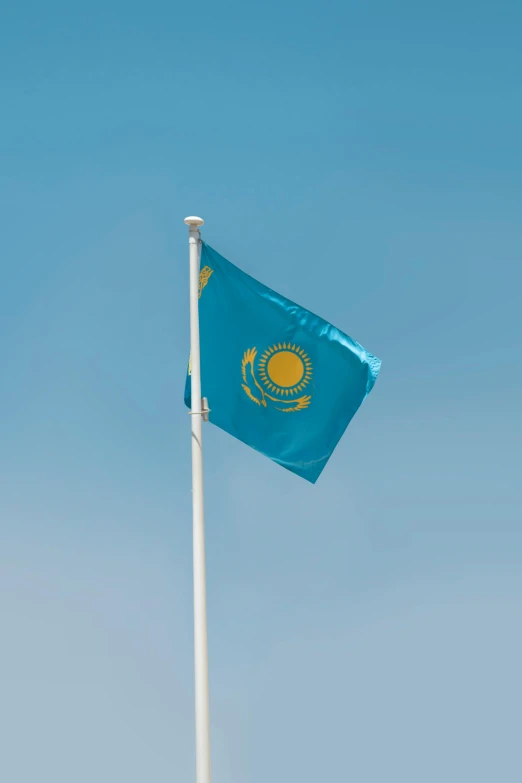 a flag flying in the blue sky with a bird