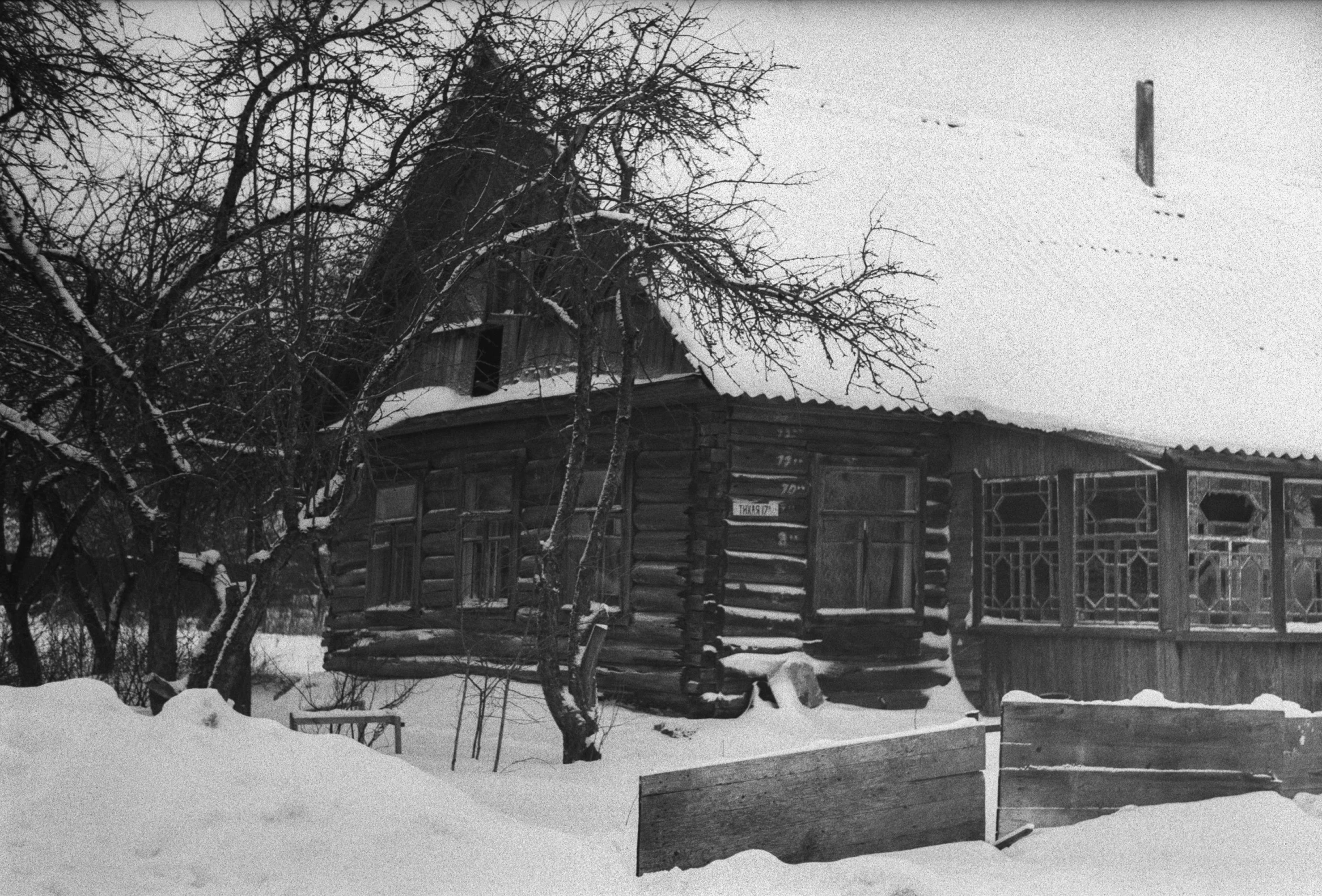 an old log cabin in the snow next to trees