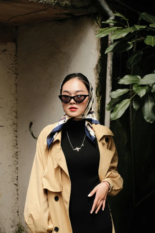 a woman posing for the camera with a trench coat