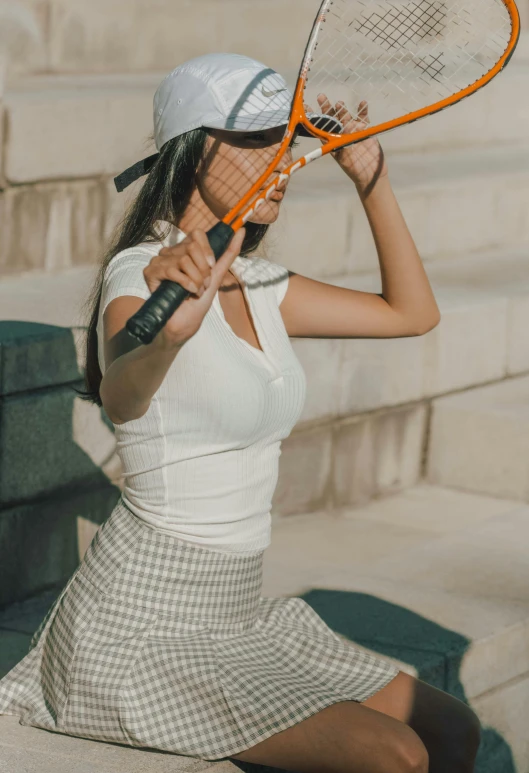 a tennis player sitting in the sun holding her racquet