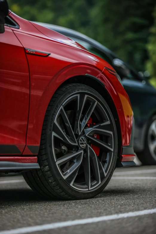 a red sports car is parked in front of a parked car