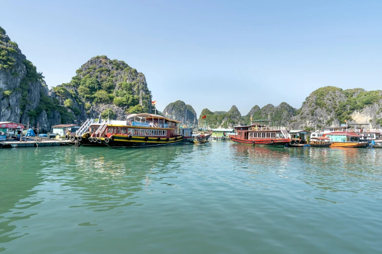 boats parked next to a large mountain with rocks