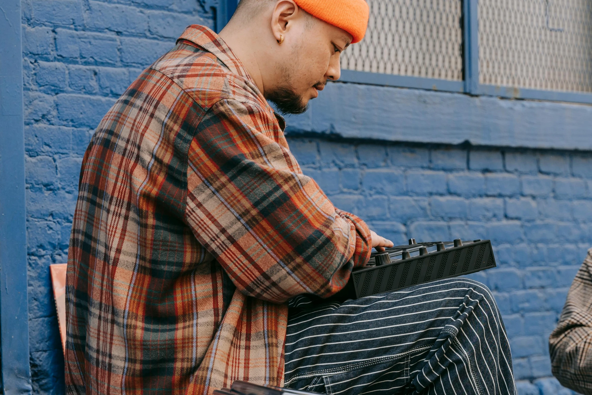 two guys in orange, blue and grey sitting next to each other