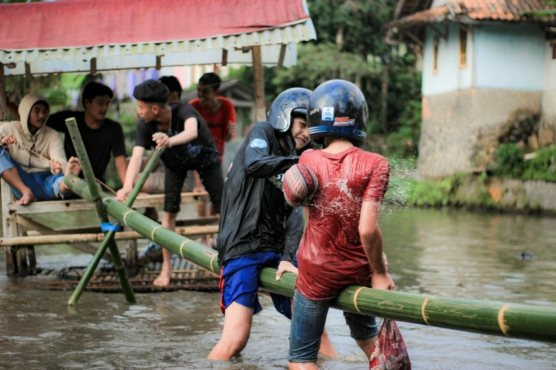people in helmets and rain gear walking through water