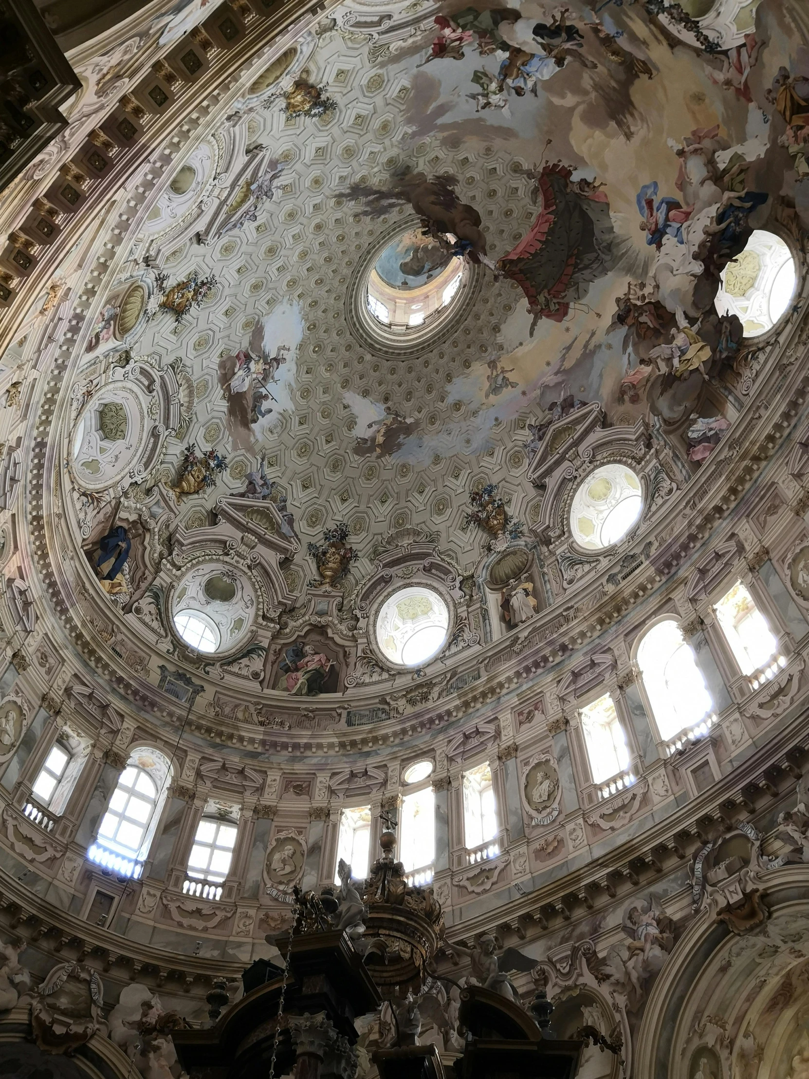 an ornate round room has circular windows, painted white