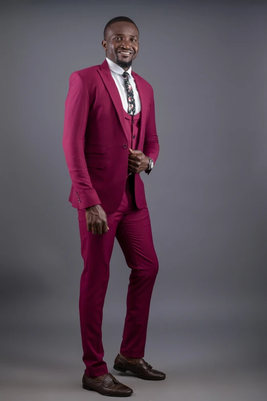 a man in a pink suit and tie poses for a pograph