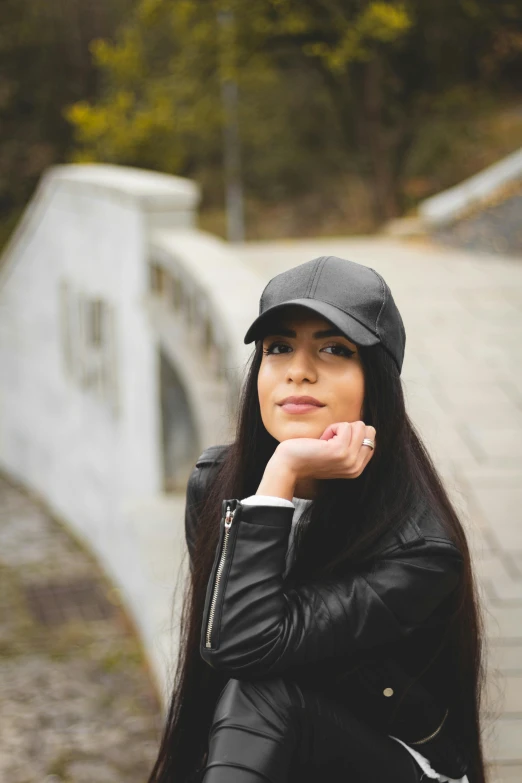 a young woman is wearing a hat and posing for the camera